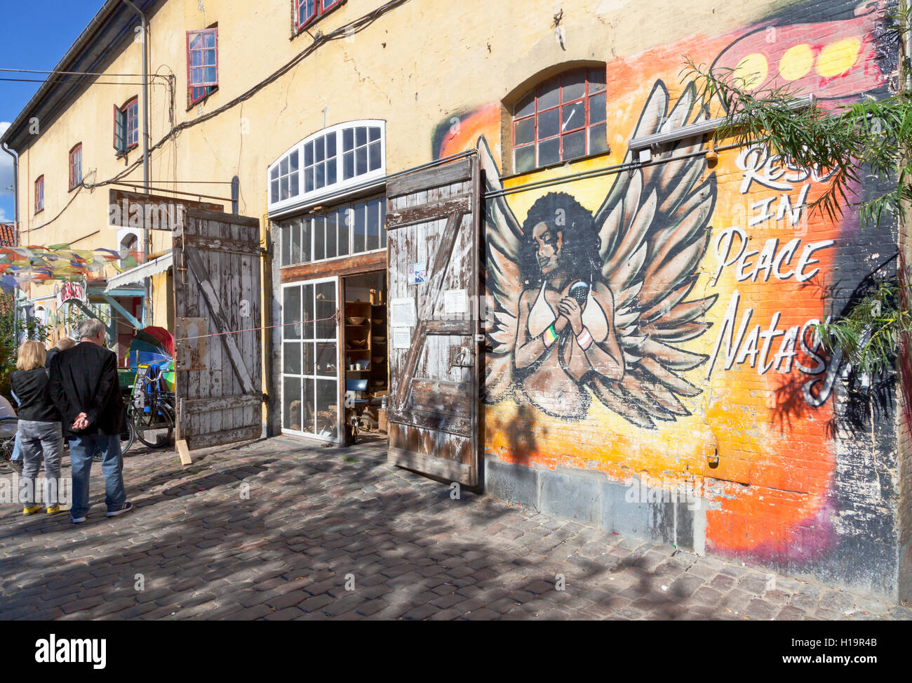 Building in Pusher Street in freetown Christiania, containing more venues and a workshop. Mural is a tribute to Natasja. Stock Photo