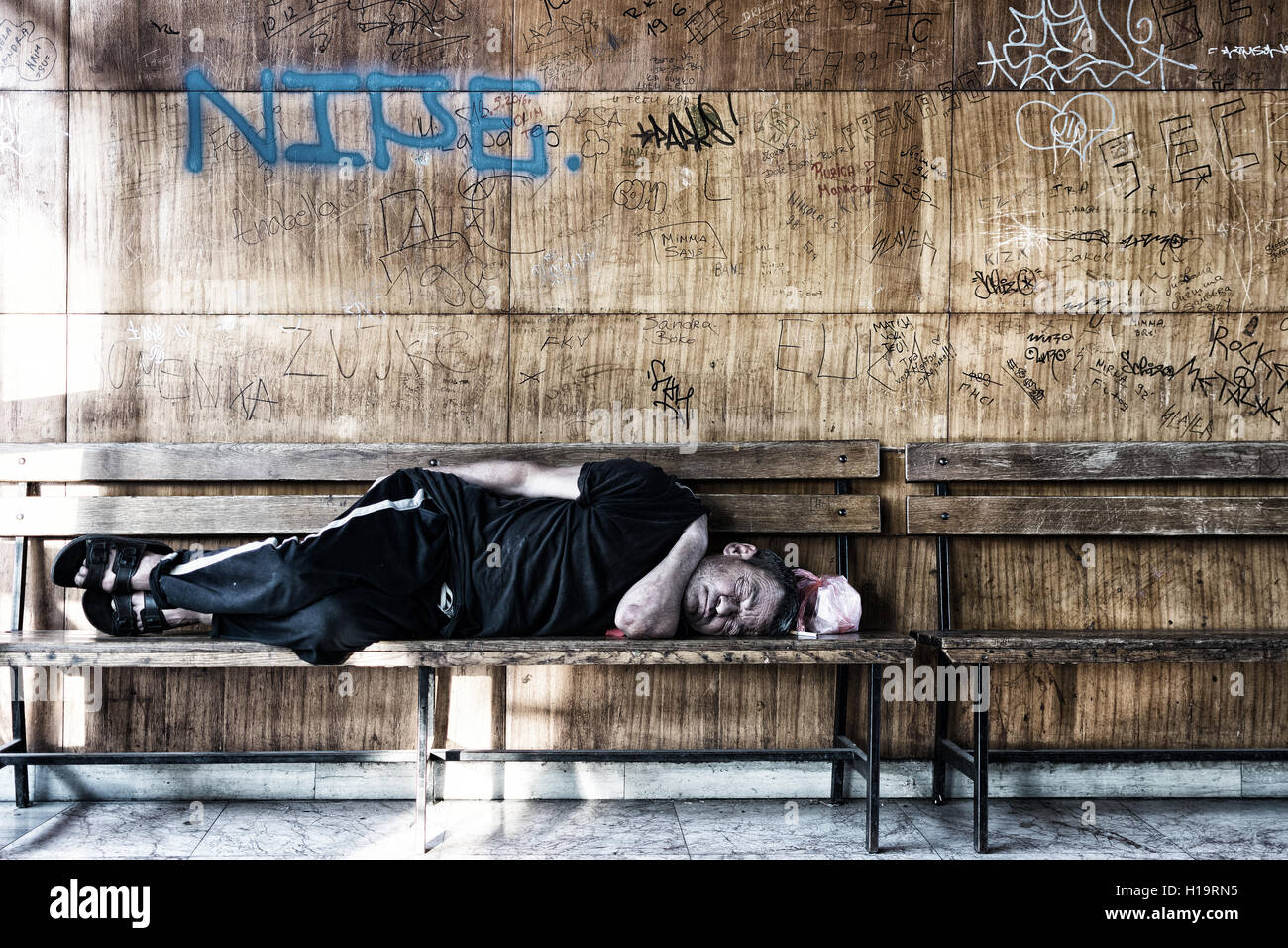 Homeless Man Sleeping on the Wooden Bench in the Train Station Stock ...