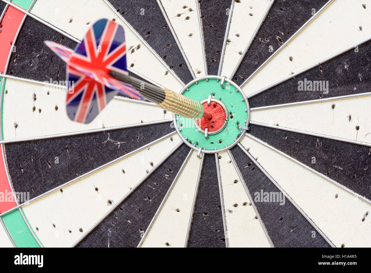 English Union Jack flag metal dart that has hit the red bullseye of a