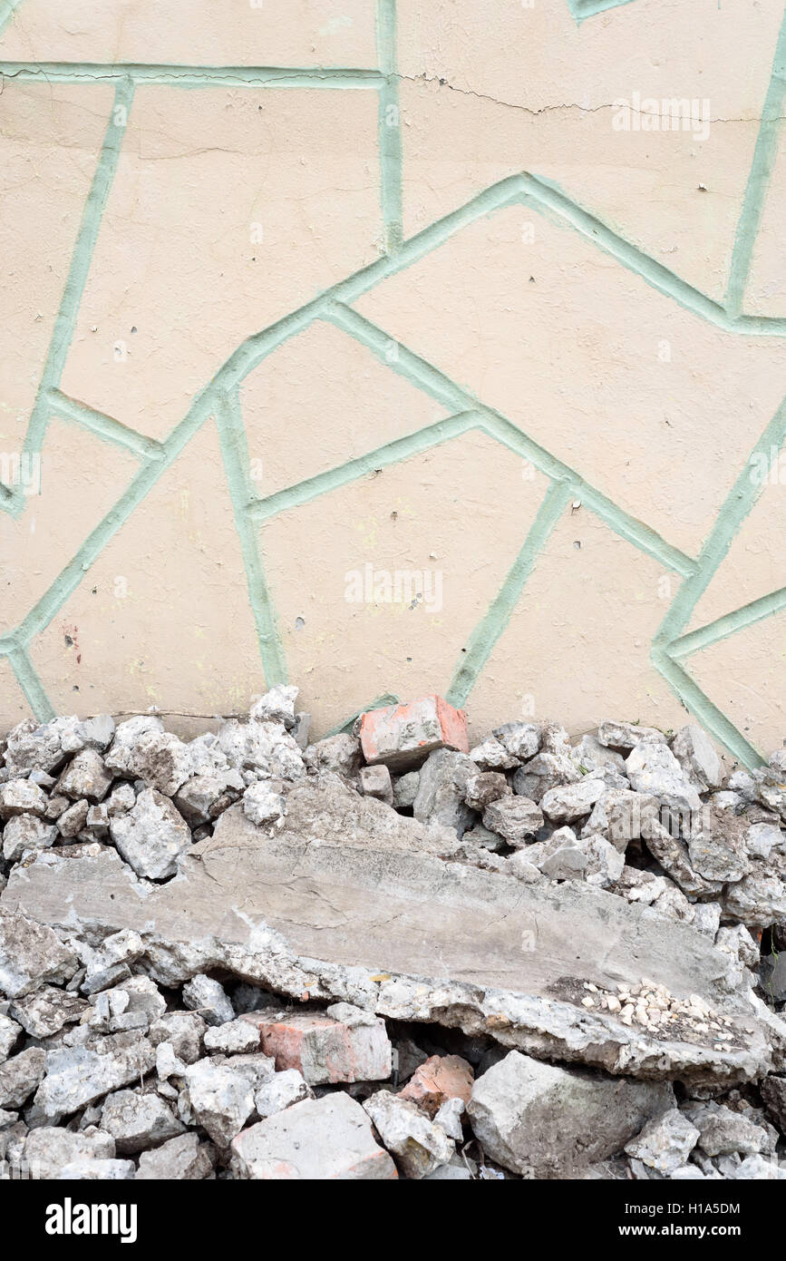 Broken rubble in chunks set against a crazy paving tiled wall Stock Photo