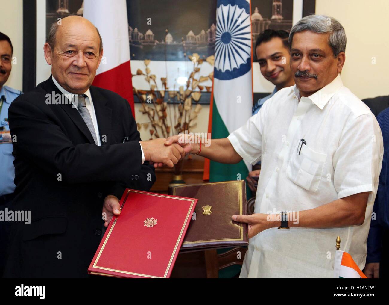 Indian Defense Minister Manohar Parrikar exchanges agreements with French Defence Minister Jean-Yves Le Drian after a signing ceremony to purchase French made Rafale fighter jets September 23, 2016 in New Dehli, India. The deal will supply 36 Dassault Aviation Rafale fighter jets reported to be worth Û7.87 billion ($8.8 billion). Stock Photo