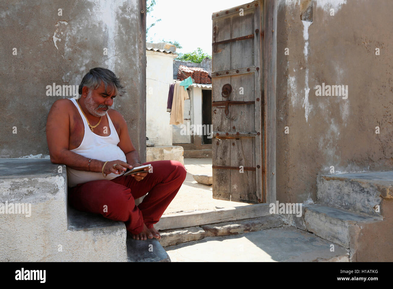 Man sitting outside the house, LAKHPAT, Kutch, Gujarat, India Stock Photo