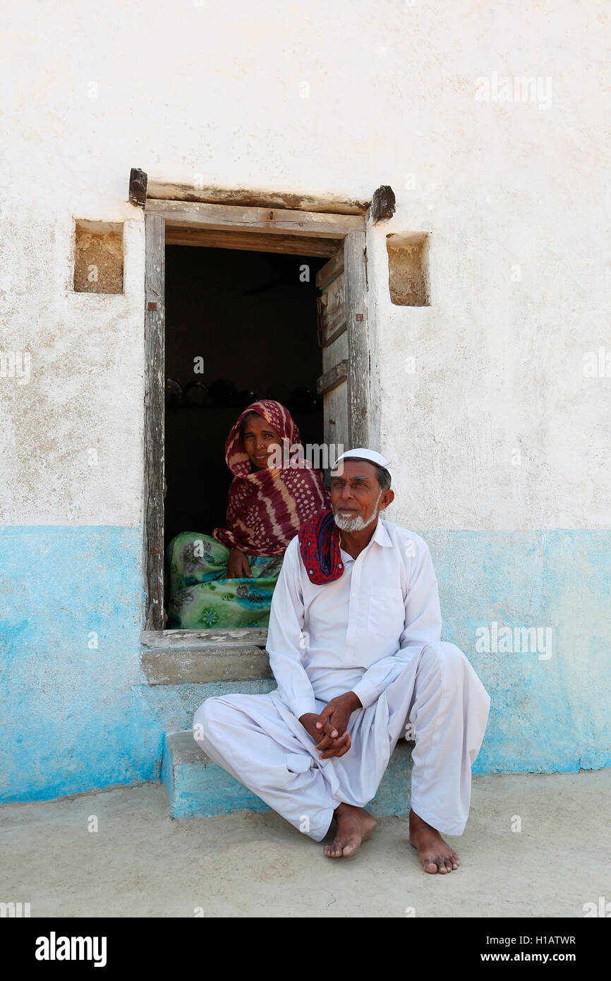 A couple sitting at the entrance, Lakhpat, Kutch, Gujrat, India Stock Photo