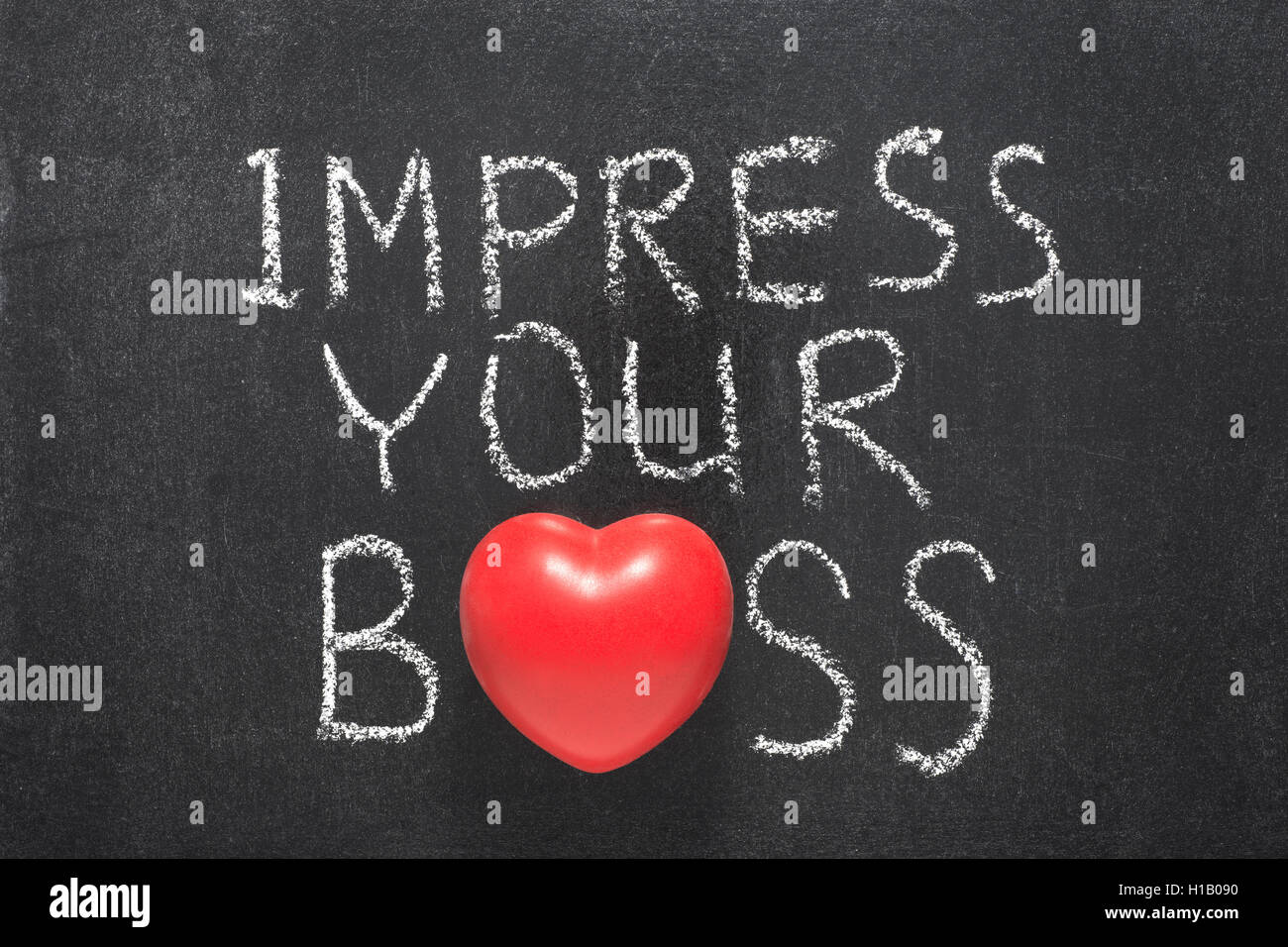 impress your boss phrase handwritten on blackboard with heart symbol instead of O Stock Photo