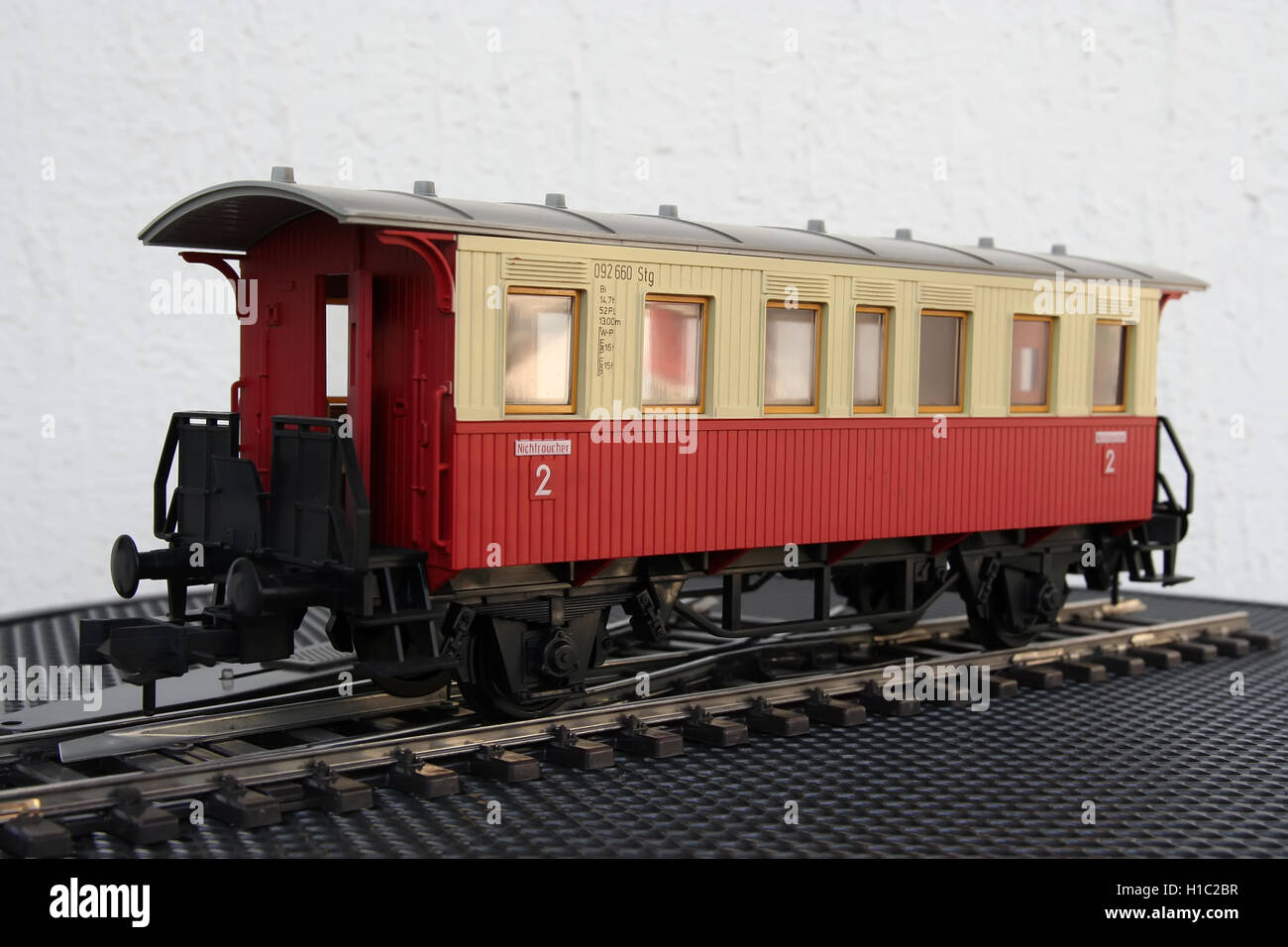 Red plastic miniature model of a train wagon. Train wagon toy. Stock Photo