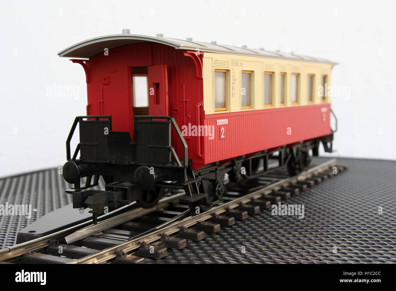 Red plastic miniature model of a train wagon. Train wagon toy. Stock Photo