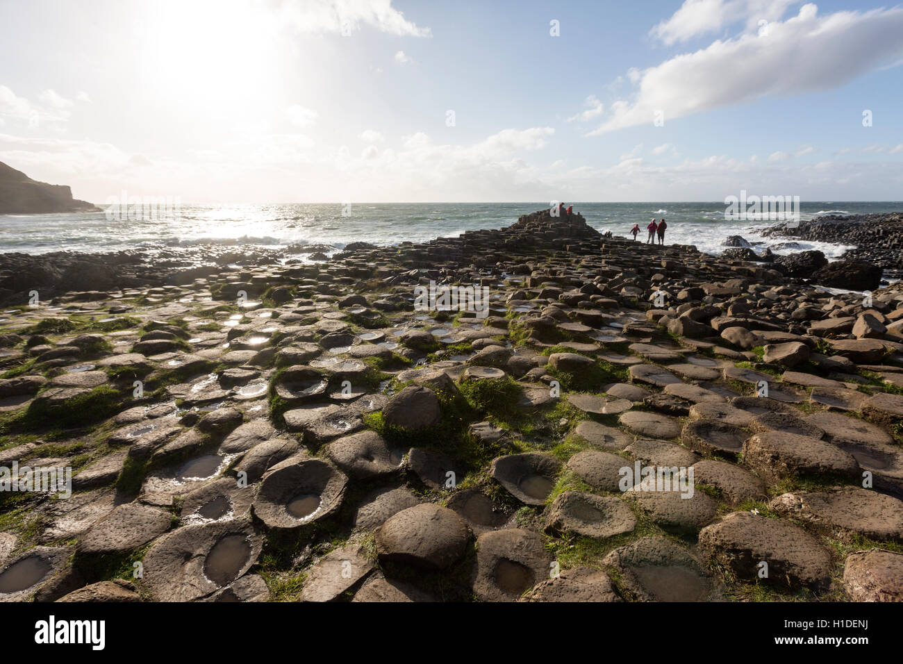 Tourists in Giant's Causeway at sunset, Bushmills, County Antrim, Northern Ireland, UK Stock Photo