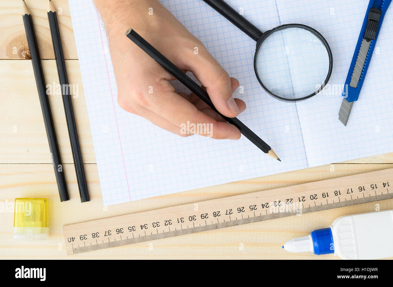 Draftsman workplace equipped with ruler, pen, stapler, scissors, magnifying glass. Stock Photo