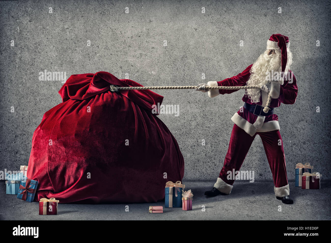 Santa Claus pulls a huge bag of gifts Stock Photo - Alamy