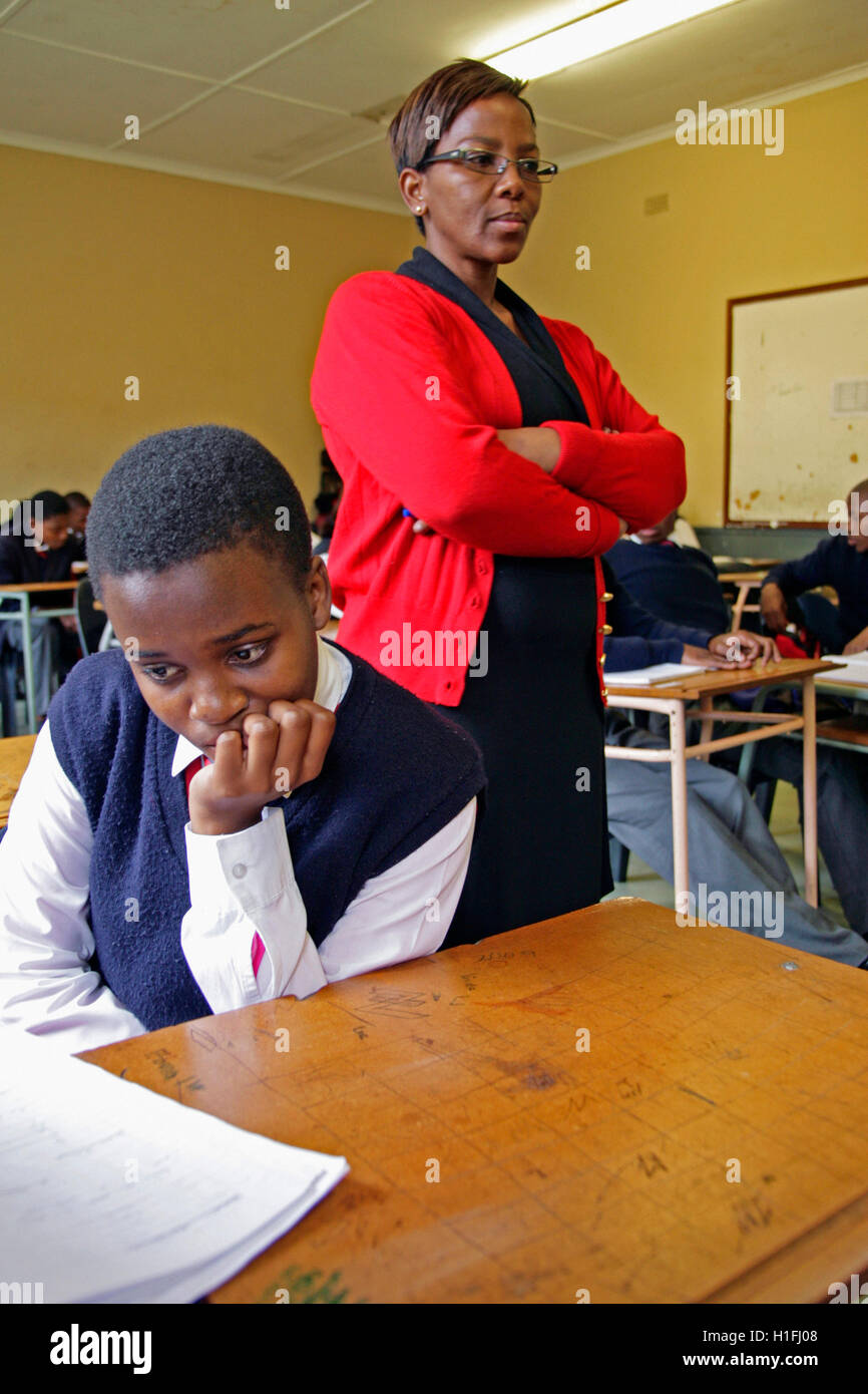 Female primary school teacher standing in a classroom gesturing to