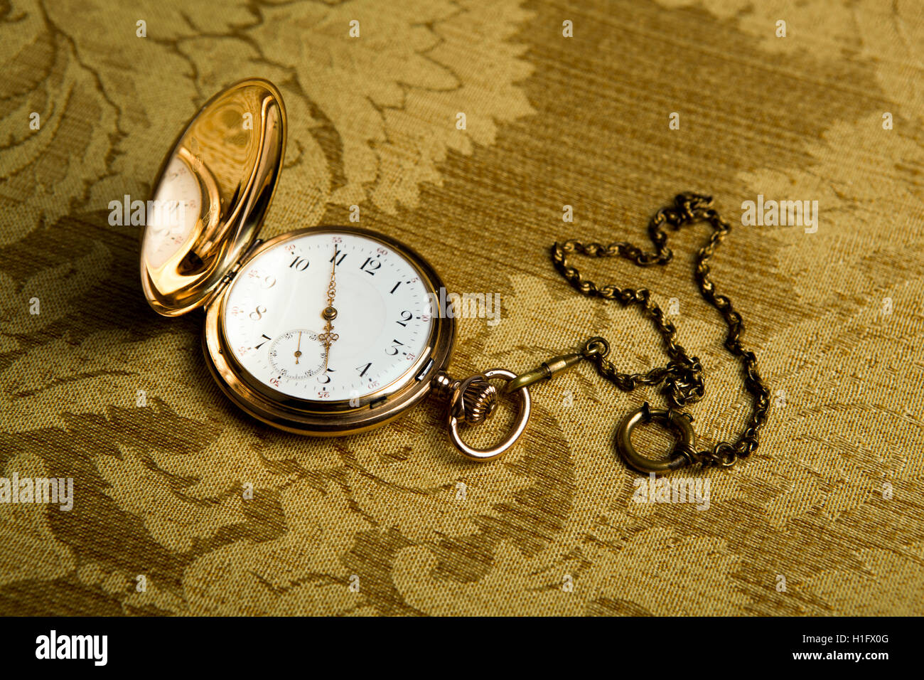 Gold pocket watch on gold cloth Stock Photo Alamy