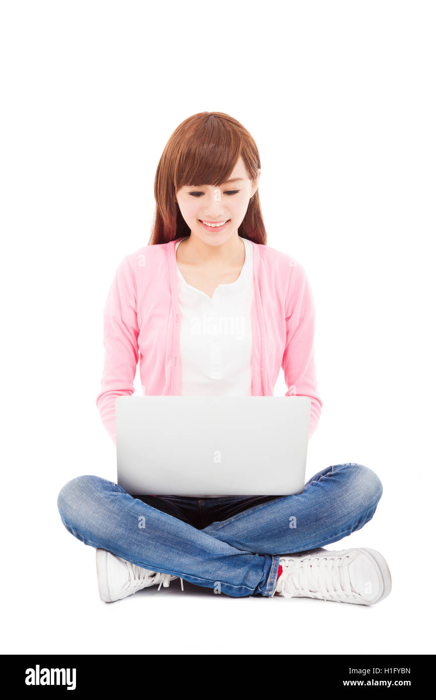 Smiling young woman sitting and using a laptop Stock Photo - Alamy