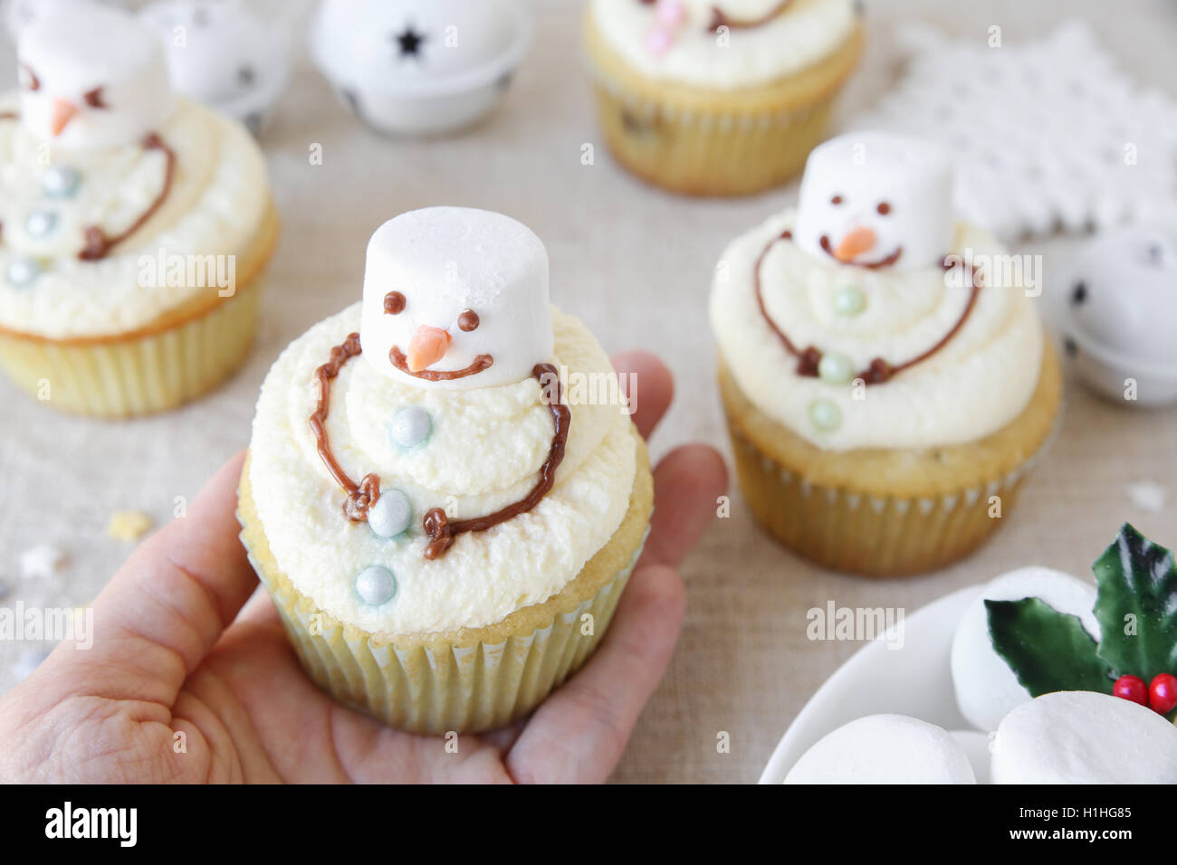 hand holding fun homemade melting snowman cupcakes for kids Stock Photo