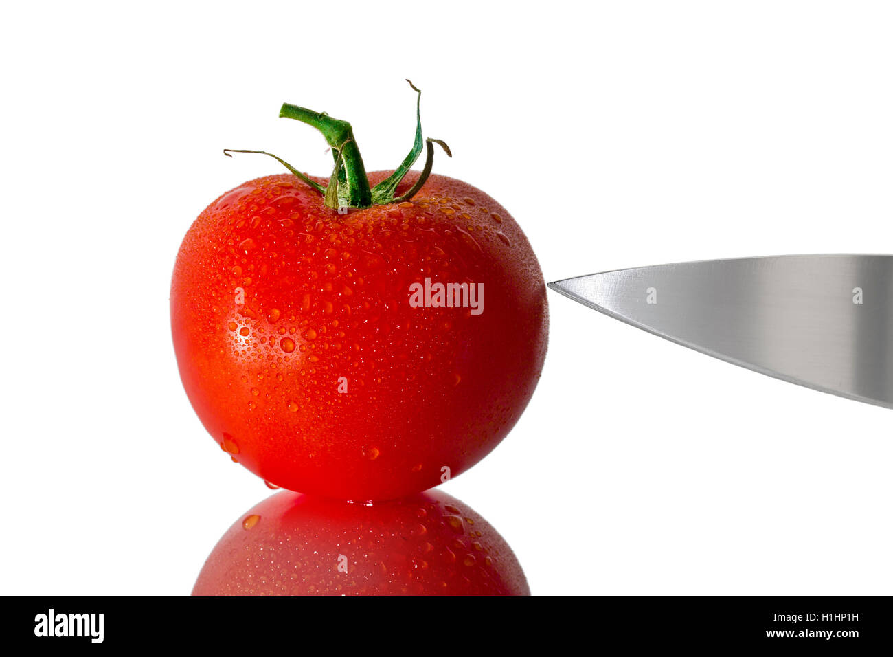 wet tomato with knife Stock Photo Alamy