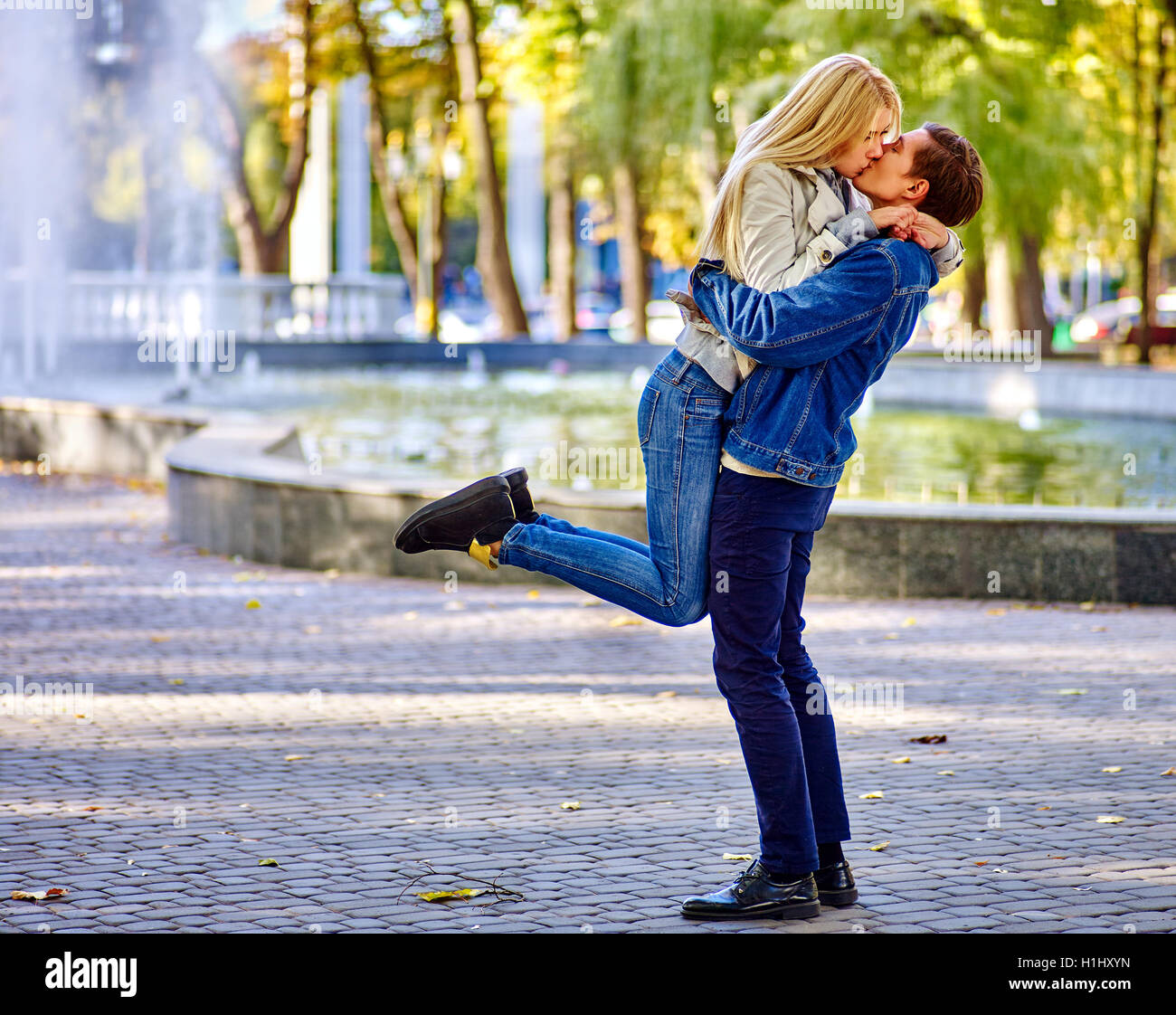 Young couple hugging and kissing in park Stock Photo - Alamy