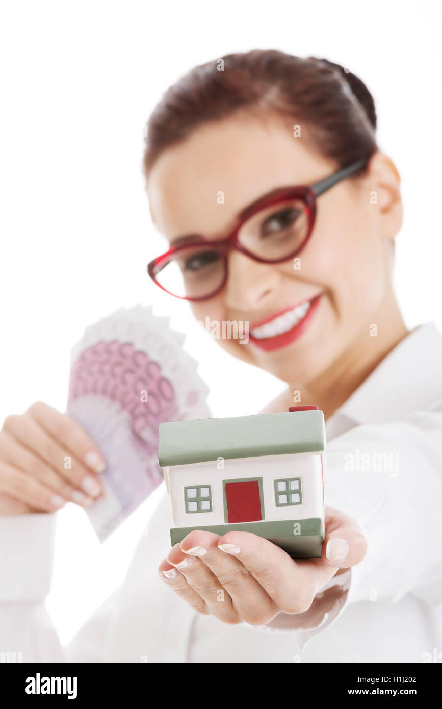 Beautiful business woman holding money and small house Stock Photo - Alamy