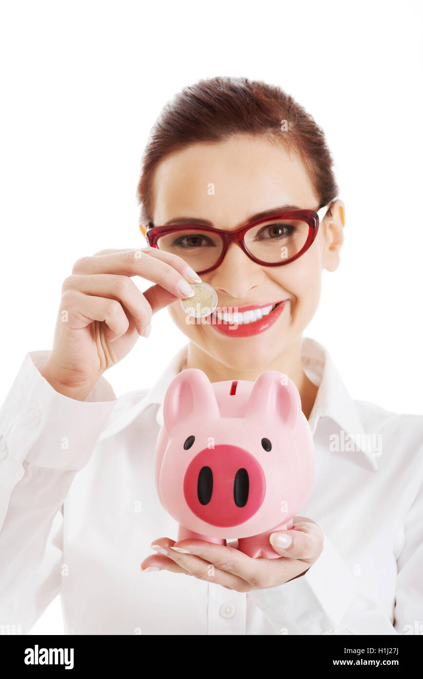 Beautiful business woman with coin and piggy- bank Stock Photo - Alamy