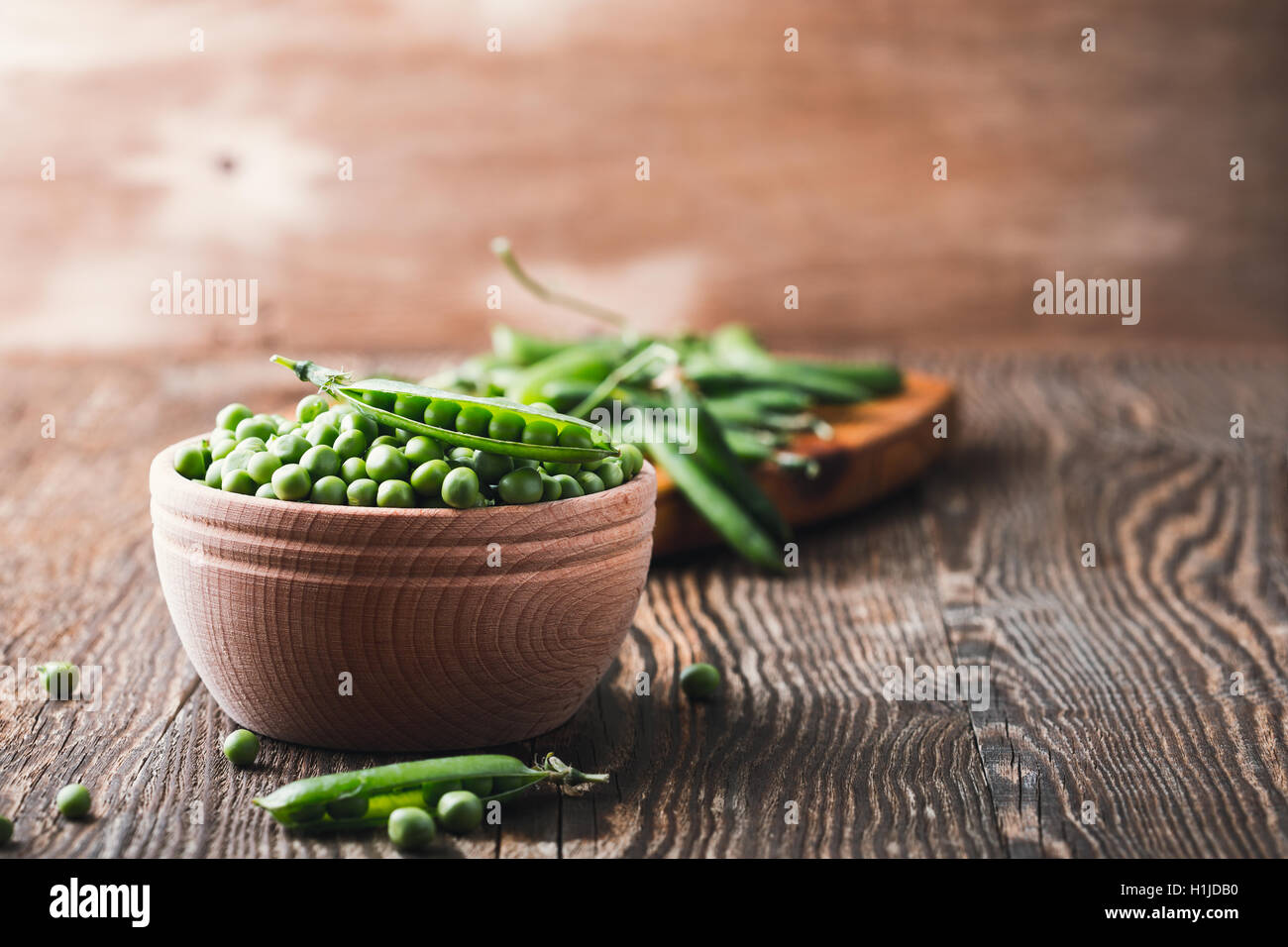 Green peas in wooden bowl on rustic background, harvest time Stock Photo