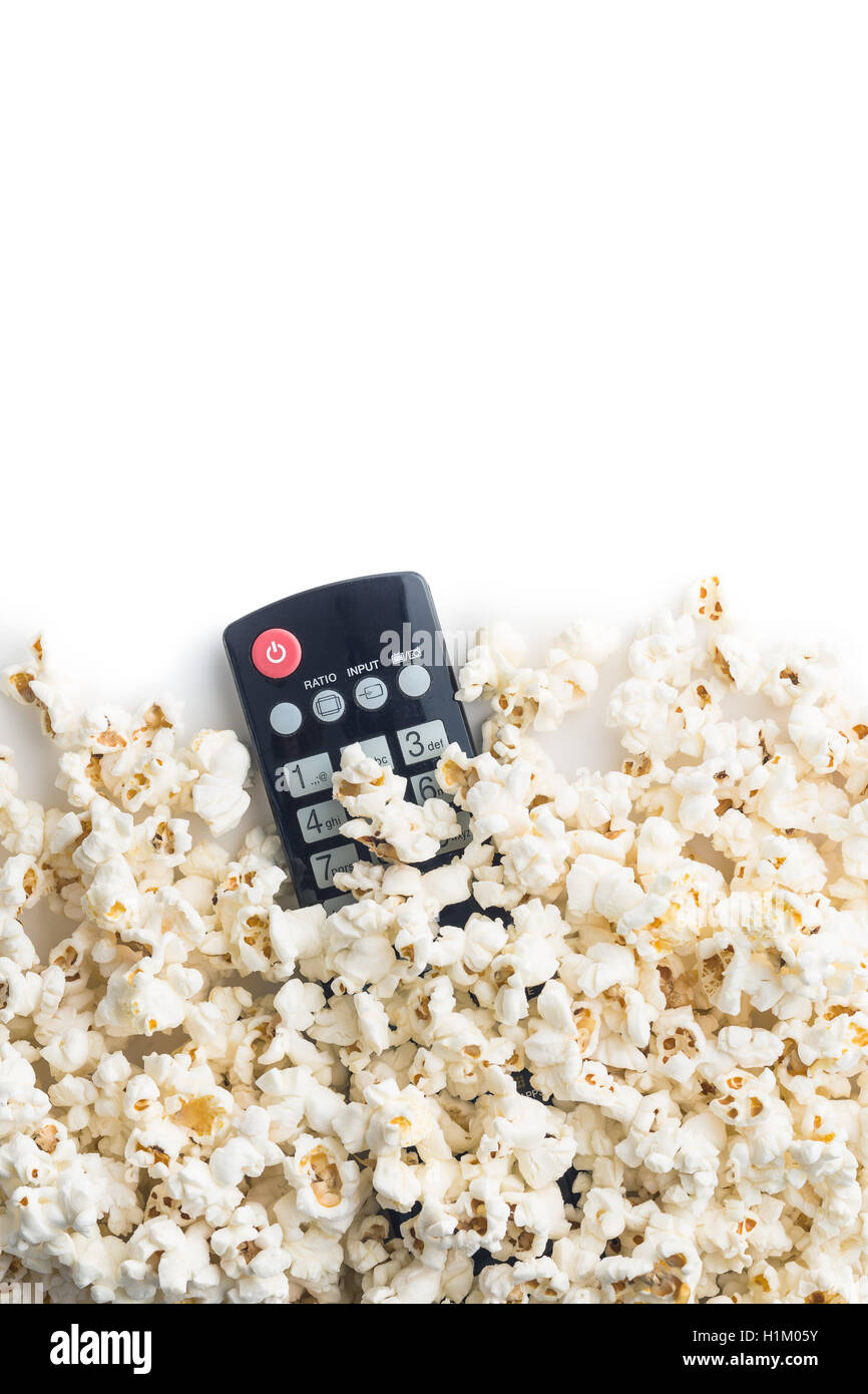 Tasty popcorn and tv remote control. Top view. Stock Photo