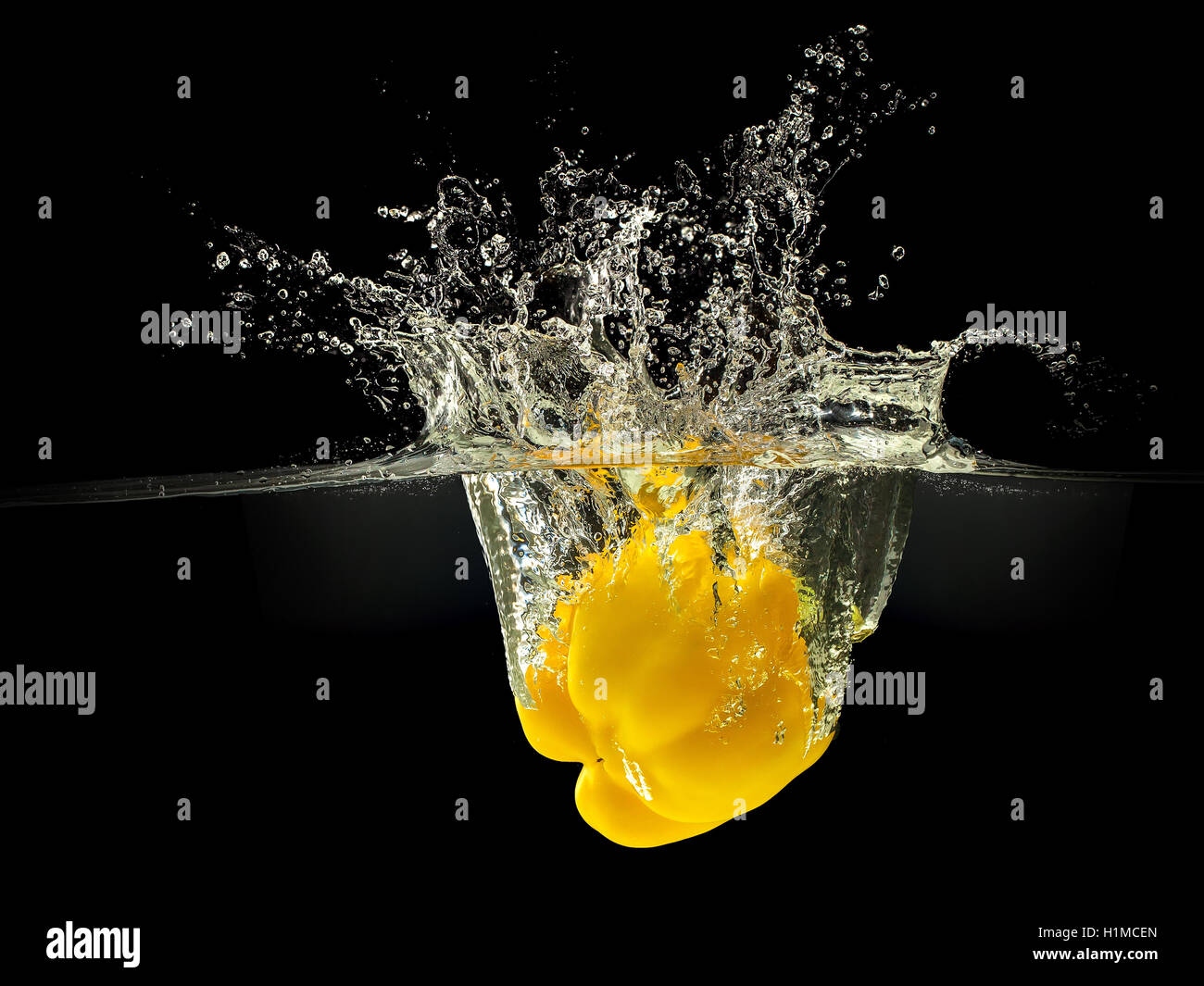 Yellow bell pepper falling in water on black Stock Photo Alamy