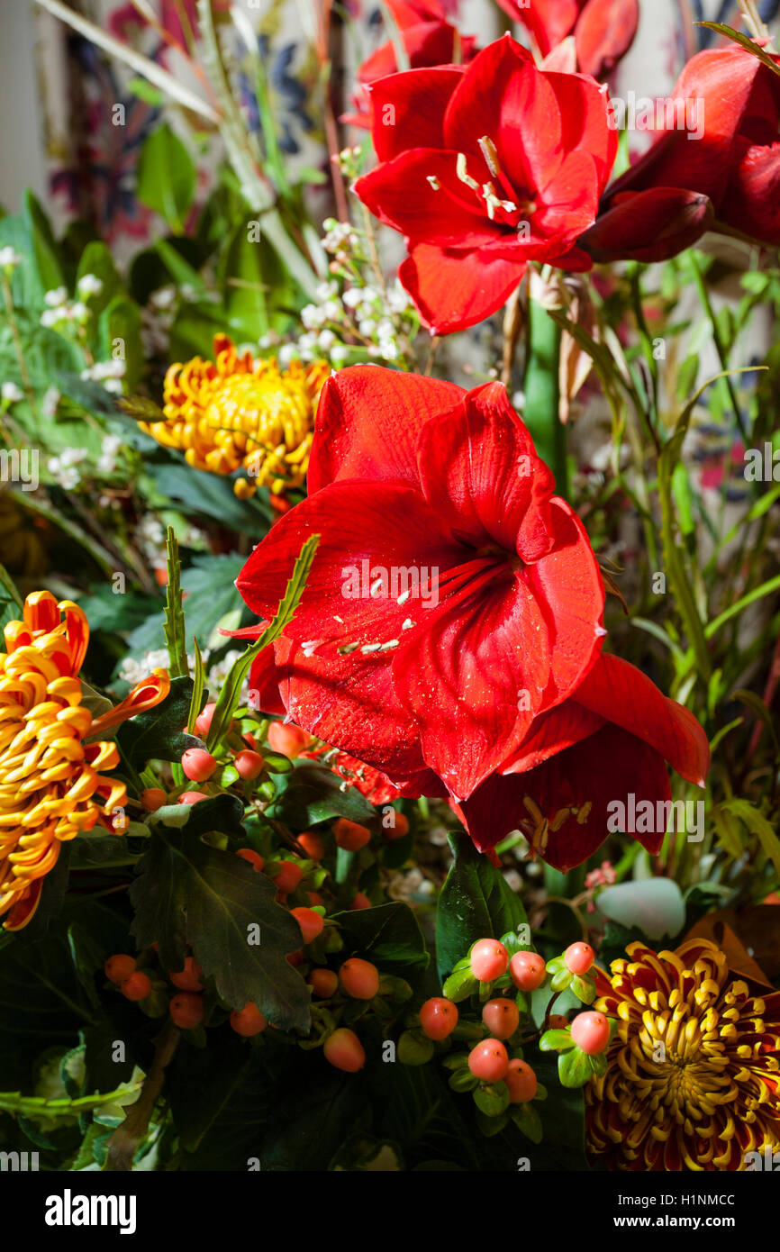Large Arrangement Of Flowers In A Glass Vase That Includes Stock
