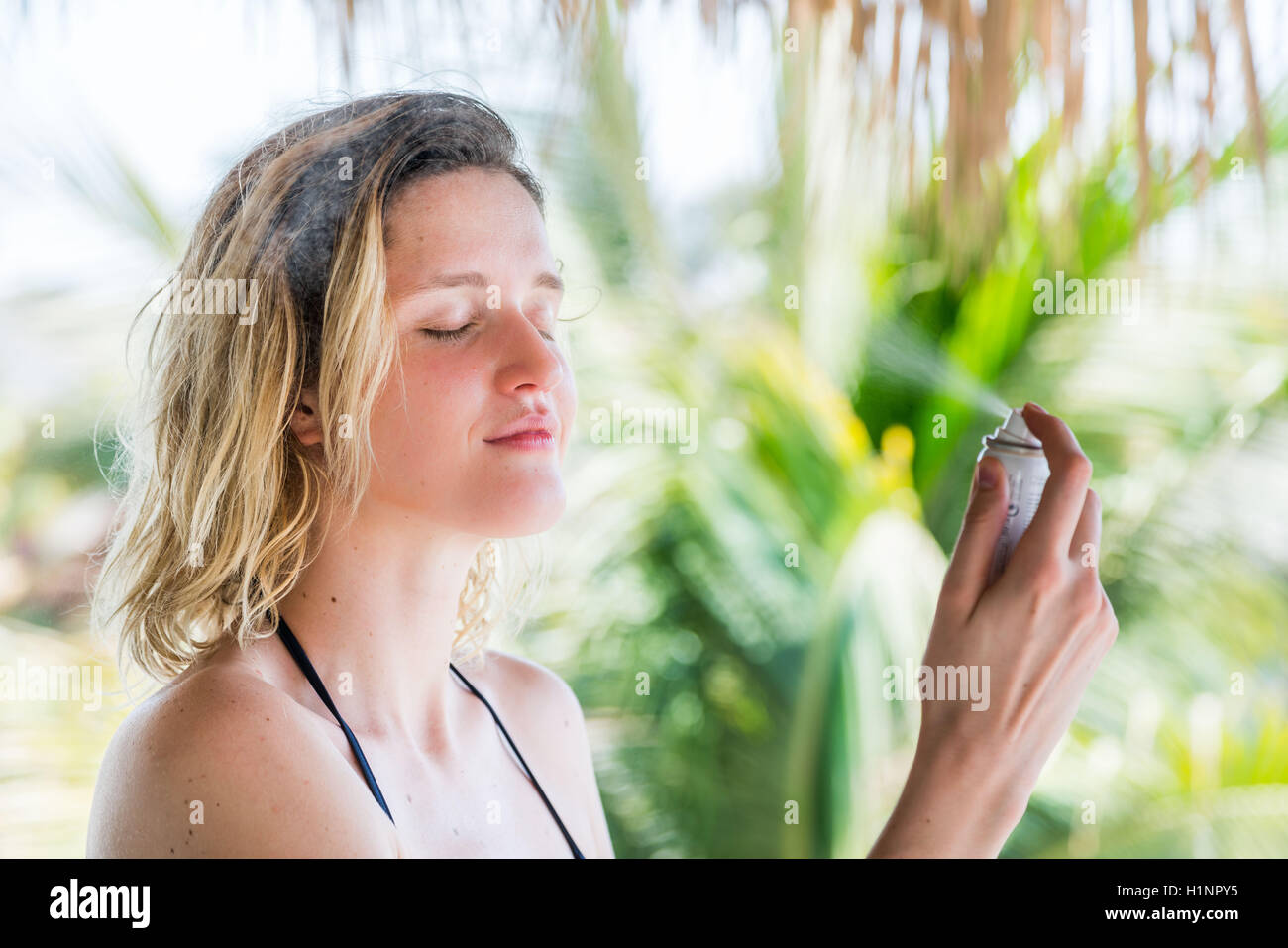 Woman spraying water on her face Stock Photo Alamy