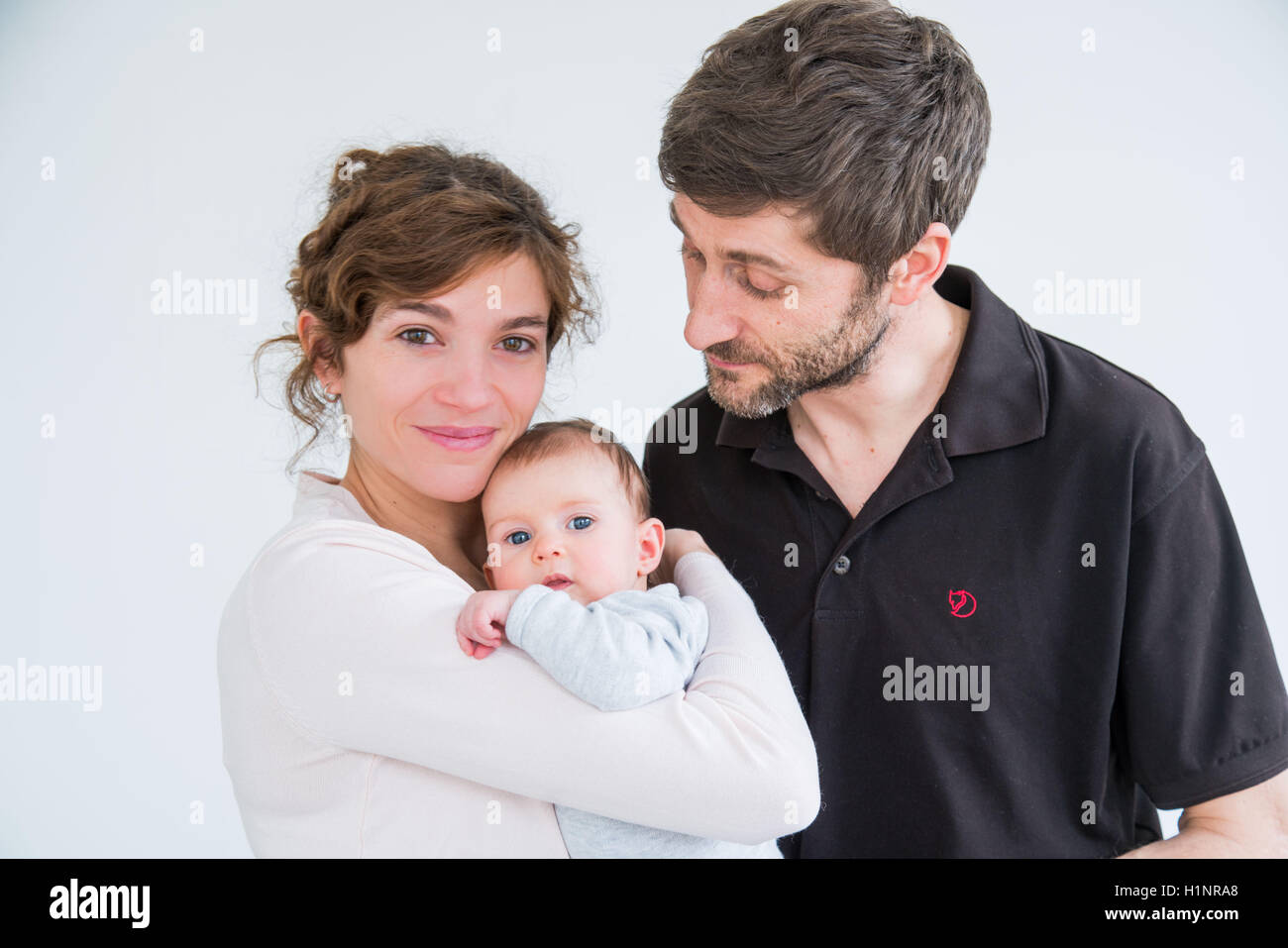 3 months old baby girl with parents. Stock Photo