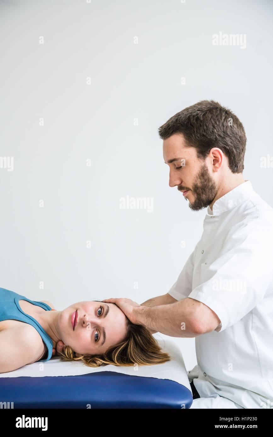 Structural osteopathy session in a woman suffering from neck pain. Stock Photo