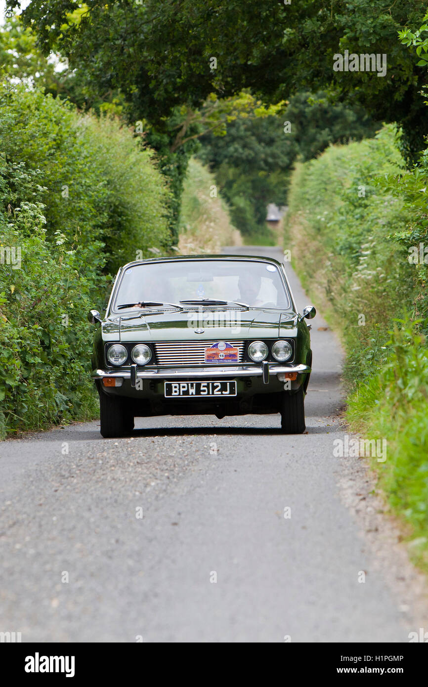Sunbeam 1971 Rapier Fastback driving up narrow country lane in Norfolk, England. Stock Photo