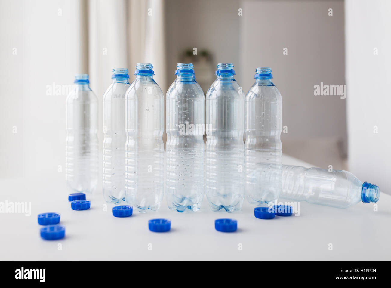 https://c8.alamy.com/comp/H1PP2H/close-up-of-empty-water-bottles-and-caps-on-table-H1PP2H.jpg