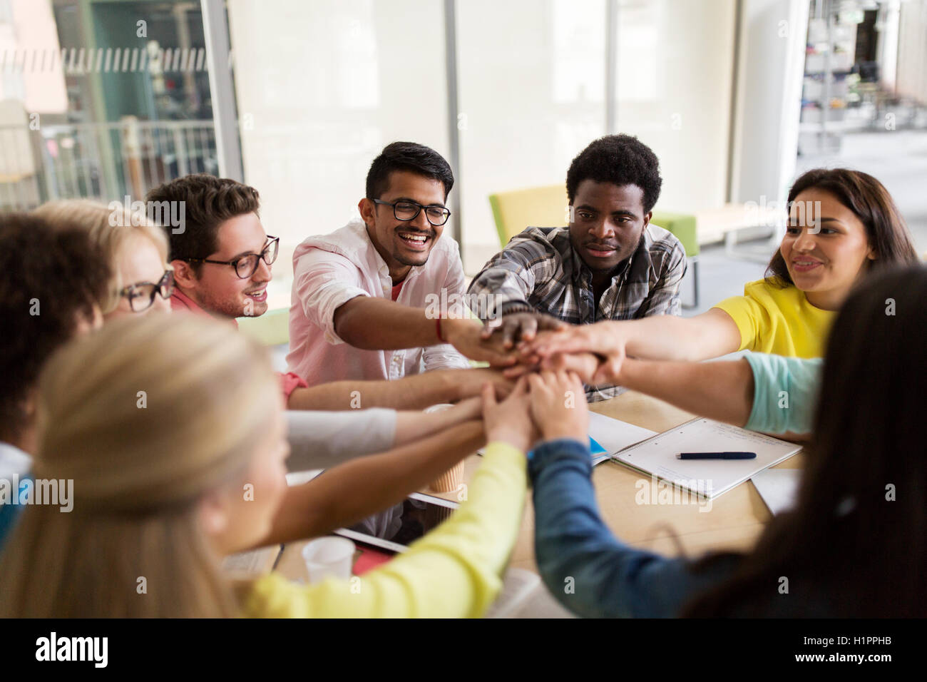 group of international students with hands on top Stock Photo - Alamy
