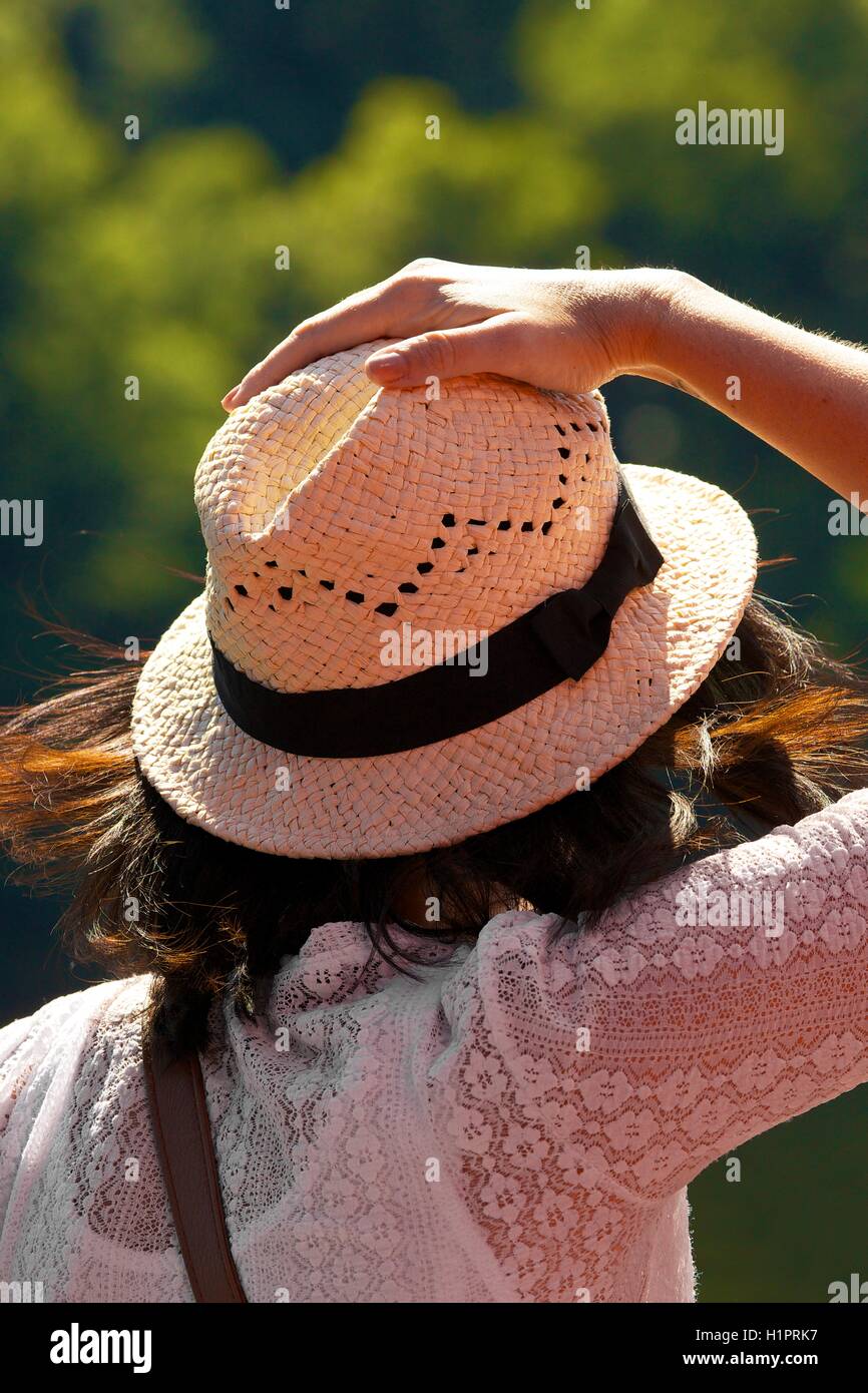 Woman holding Panama hat on against the wind. Stock Photo