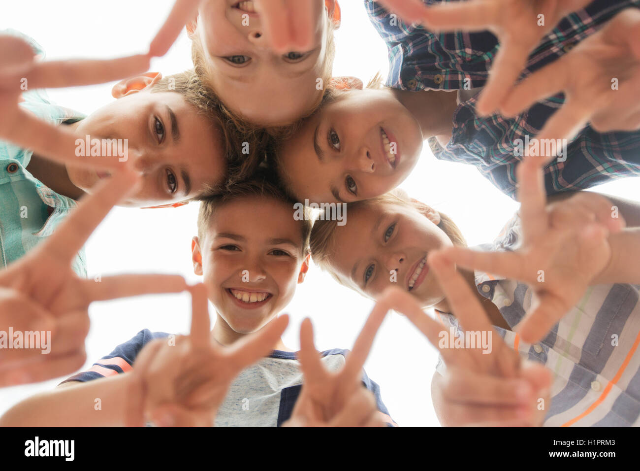 group of happy children showing v sign in circle Stock Photo