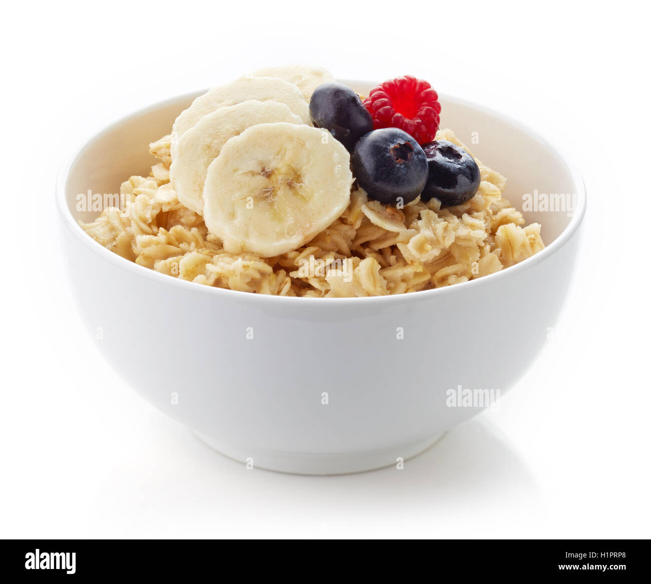 Bowl of healthy oatmeal with banana and fresh berries isolated on white background Stock Photo