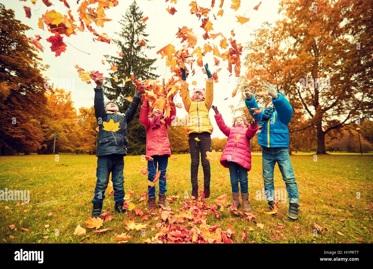 happy children playing with autumn leaves in park Stock Photo - Alamy