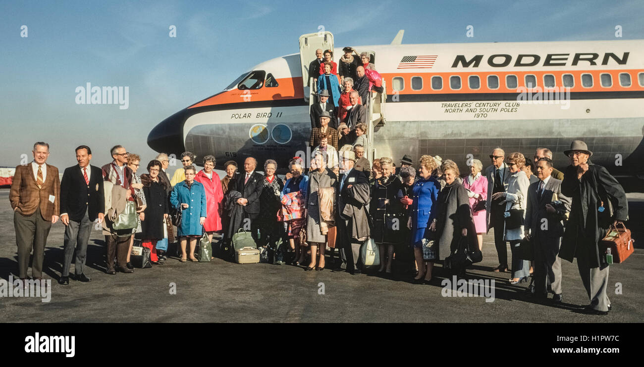 Passengers pose for a picture before embarking on their Convair 990 jet plane, a Modern Air Transport charter called 'Polar Bird II,' which would carry 48 passengers via the North Pole and South Pole on a unique 32-day around-the-world tour organized by Hemphill World Air Cruises of Los Angeles, California, for the Travelers' Century Club. It was the most expensive world tour of the time (1970) at $9,760 per person. Stock Photo