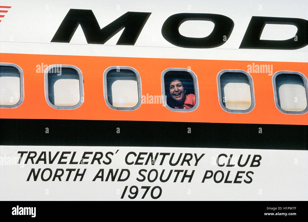 A passenger looks out the window of a Convair 990 jet that was a Modern Air Transport charter called 'Polar Bird II.'  The plane carried 48 passengers via the North Pole and South Pole on a unique 32-day around-the-world tour organized by Hemphill World Air Cruises of Los Angeles, California, for the Travelers' Century Club. It was the most expensive world tour of the time (1970) at $9,760 per person. Stock Photo