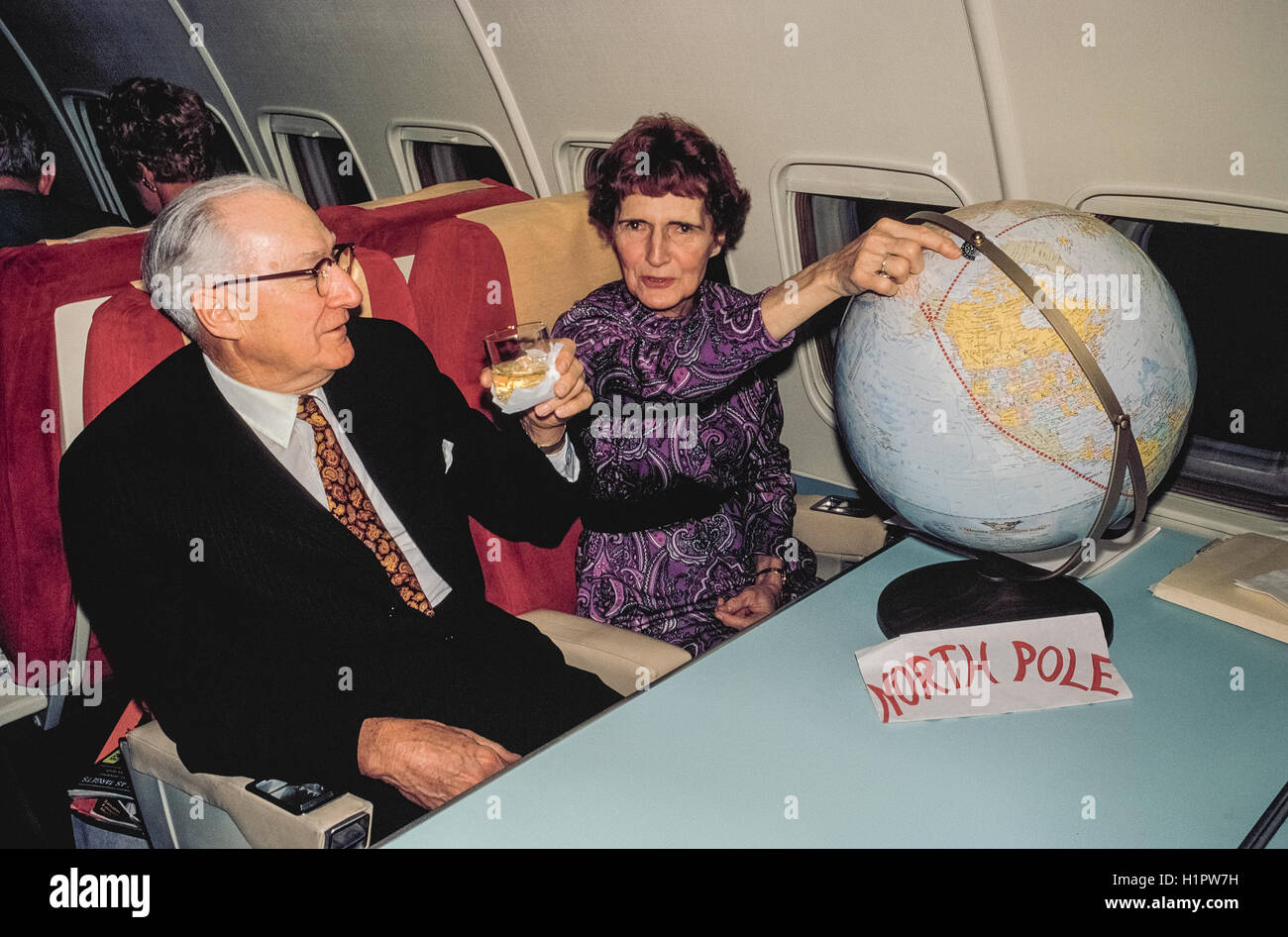 A married couple celebrate crossing the North Pole aboard a Convair 990 jet that was a Modern Air Transport charter flight called "Polar Bird II." The plane carried 48 passengers via the North Pole and South Pole on a unique 32-day around-the-world tour organized by Hemphill World Air Cruises of Los Angeles, California, for the Travelers' Century Club. It was the most expensive tour of the time (1970) at $9,760 per person, or $19,520 per couple. Stock Photo