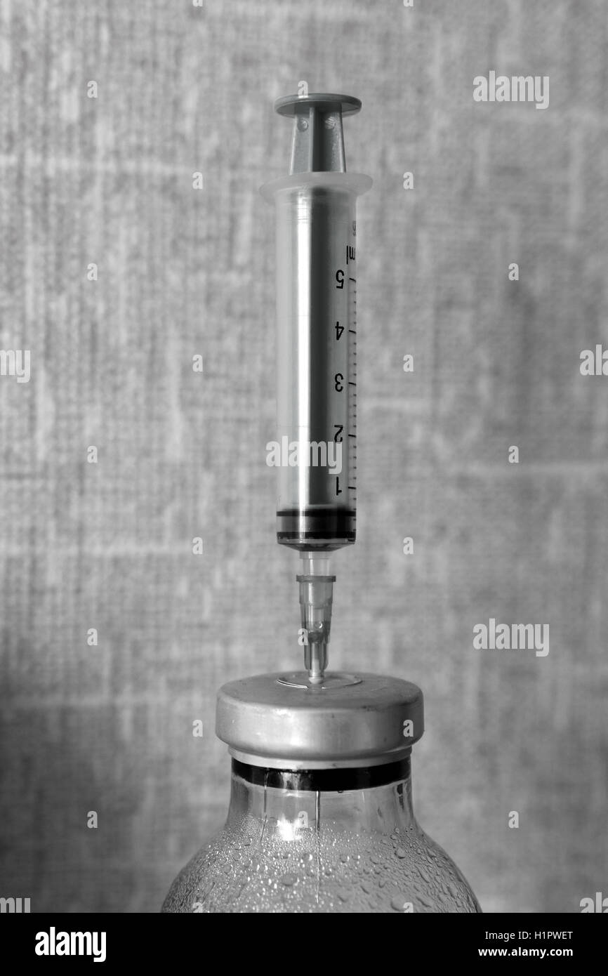 plastic syringe stuck into the bottle of medicine Stock Photo Alamy