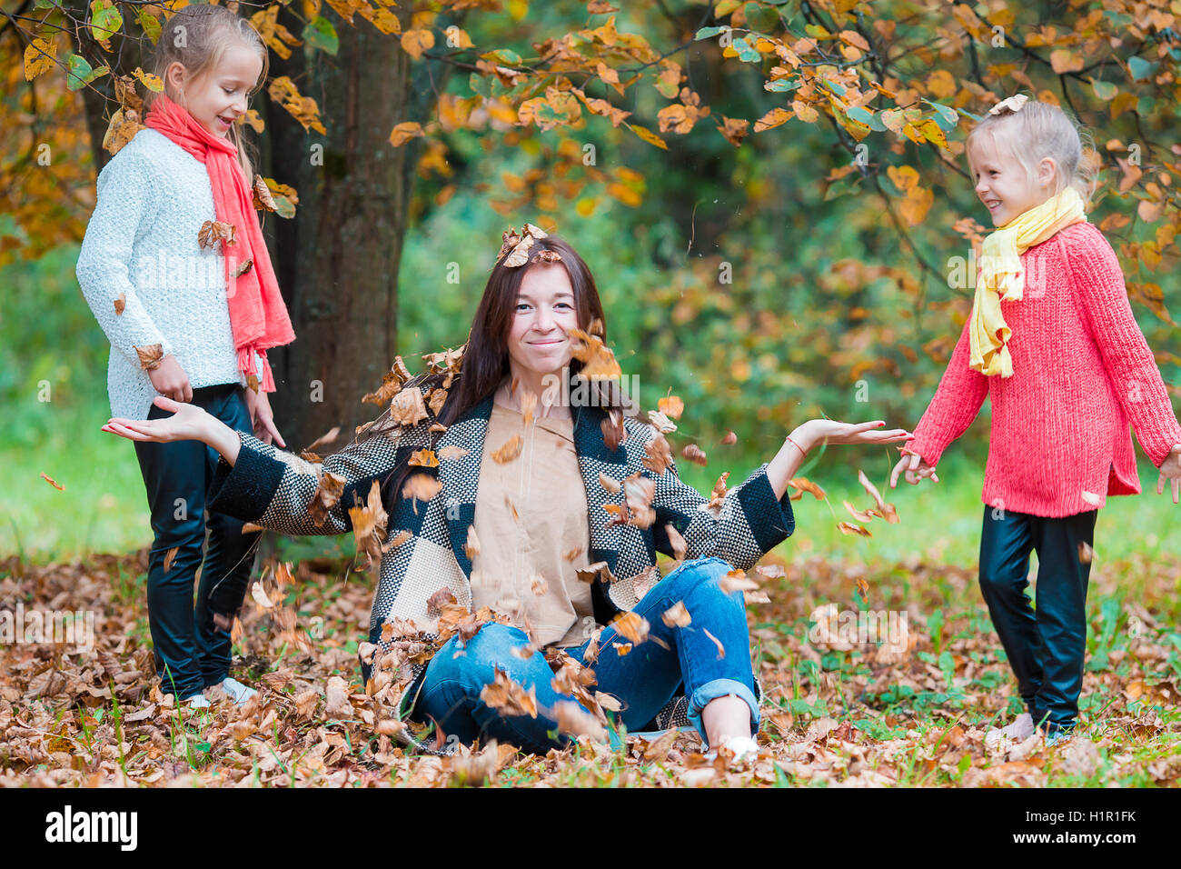 Adorable little girls and young mother in autumn park outdoors Stock ...