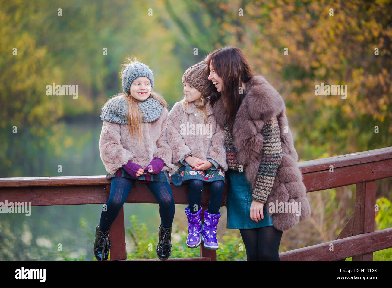 Adorable little girls and young mother in autumn park outdoors Stock ...