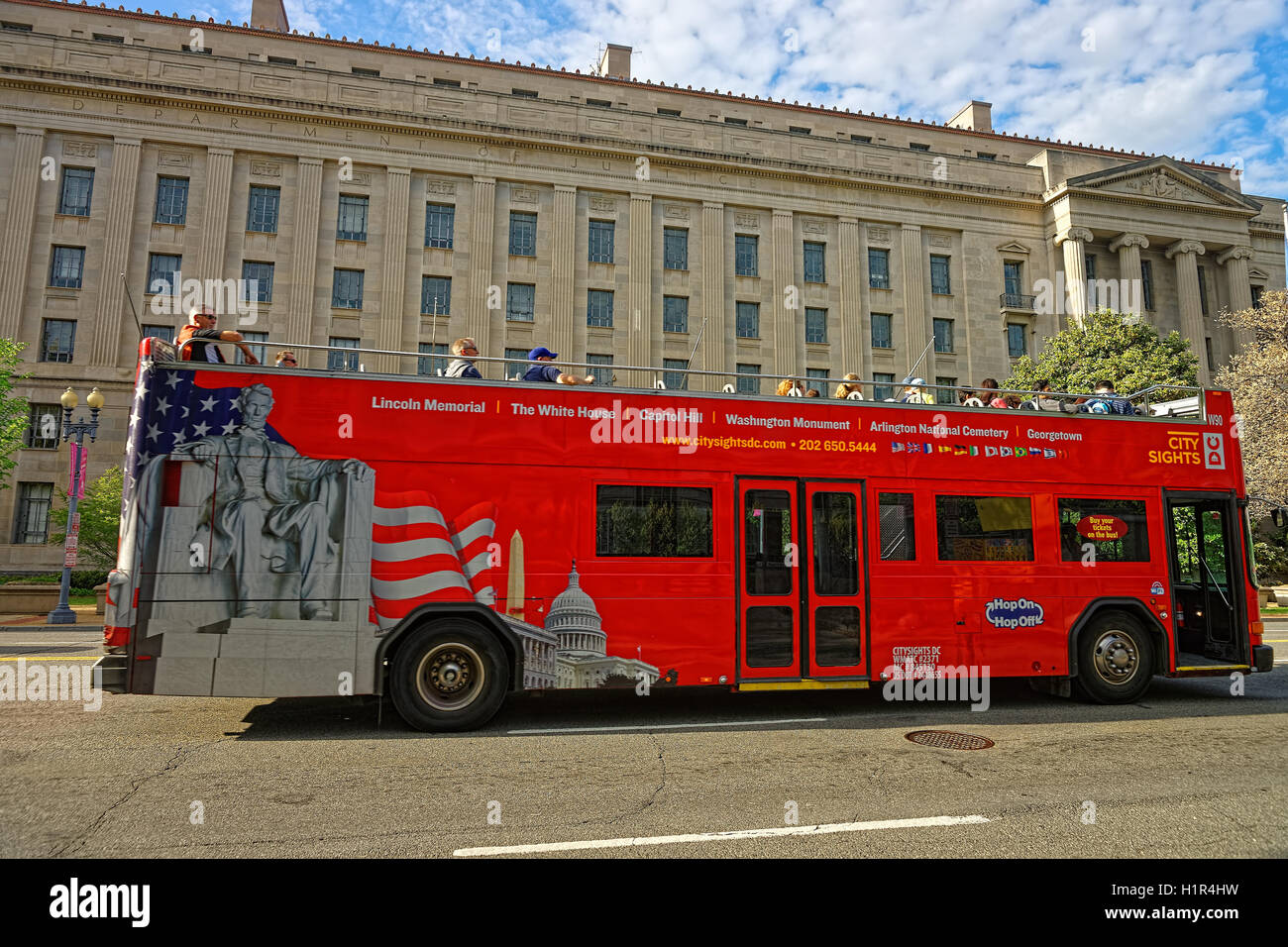 Washington D.C., USA - May 2, 2015: Tourist bus with people was seen near the Department of Commerce in Washington D.C. It is located in Herbert C. Hoover Building. It was built in 1932. Stock Photo