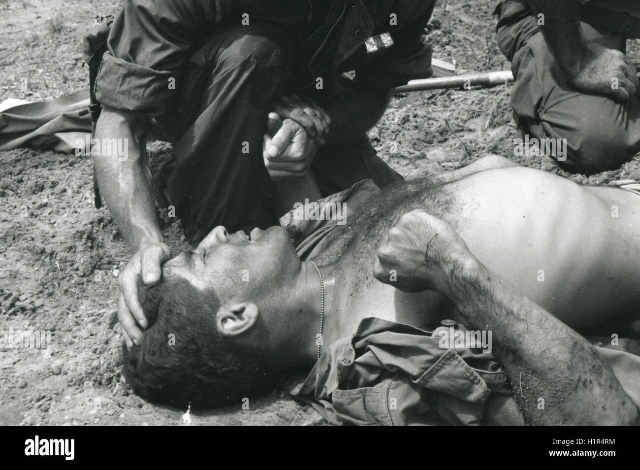 A young Marine wounded by a Viet Cong booby trap is comforted by a fellow Marine. Stock Photo