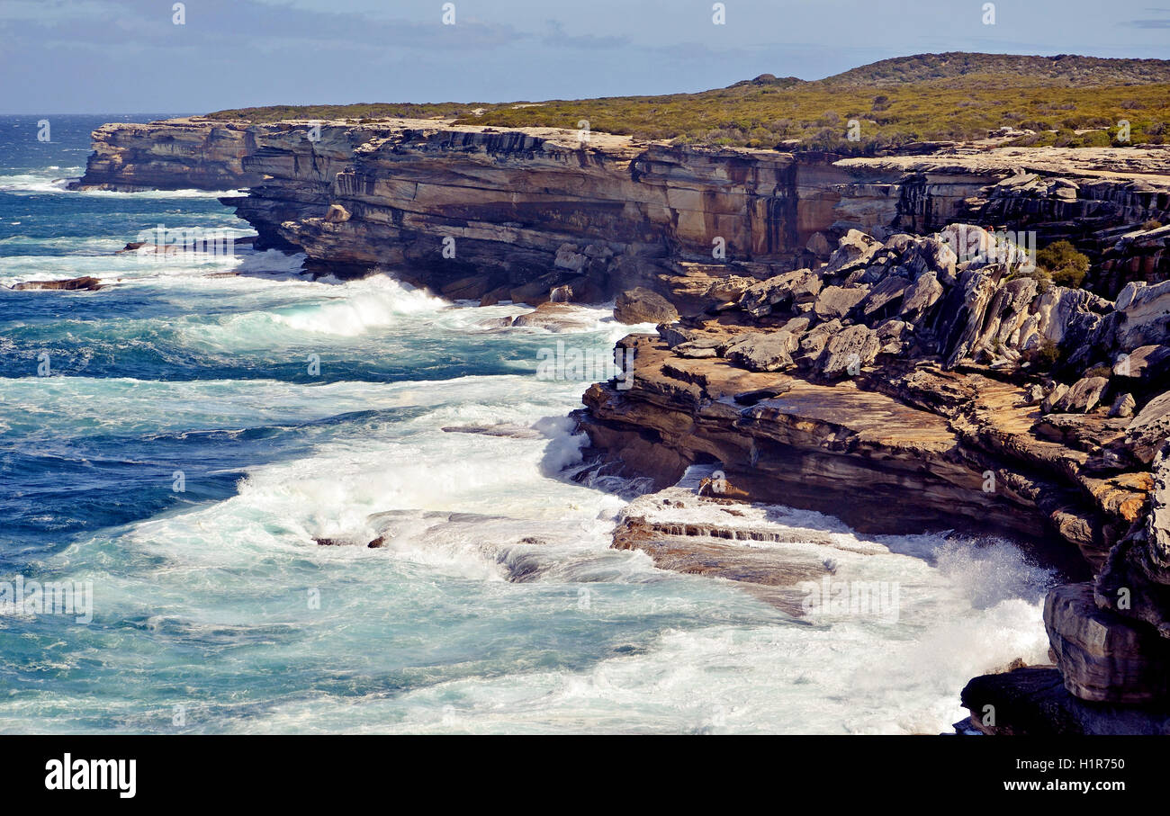 Weathered, rugged sandstone cliffs of Cape Solander, New South Wales coastline, Australia. Rock collapse from erosion common. Stock Photo