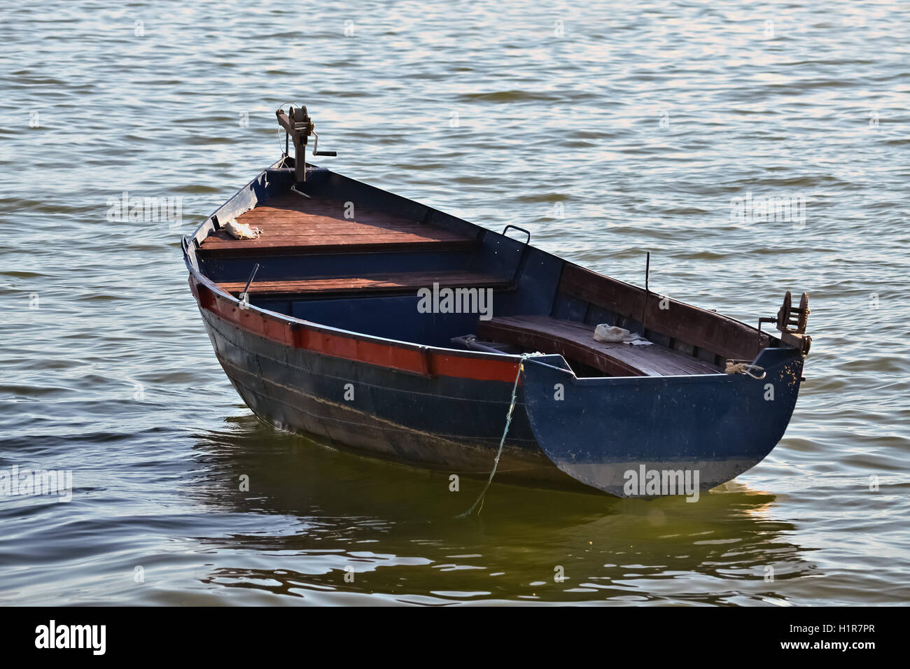Anchored old rowboat and its reflection in the lake Stock Photo