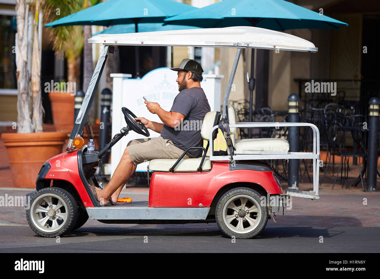 Man Texting While Driving His Golf Cart Along A Street In Avalon, Santa