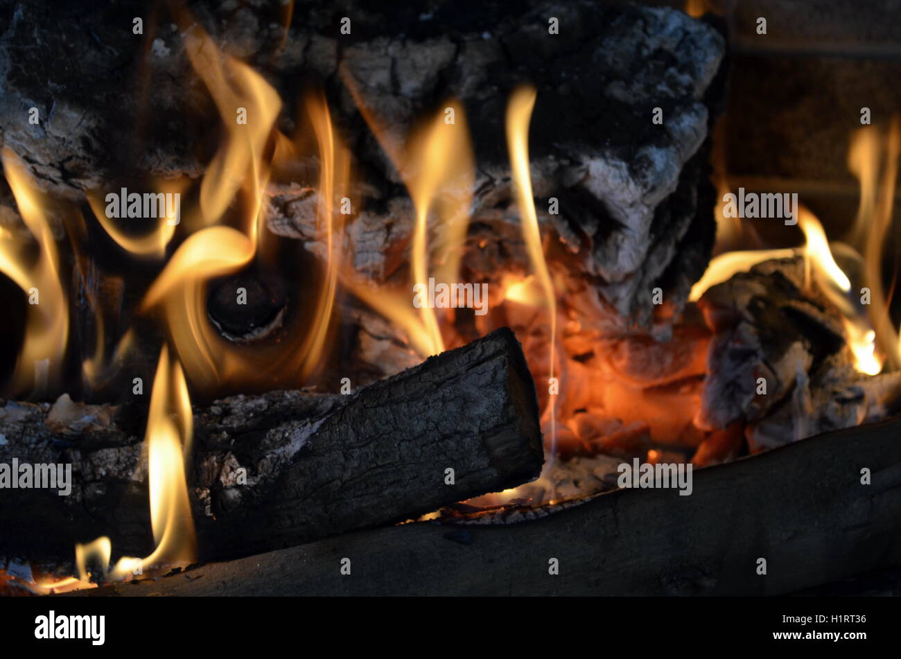 A big burning fire in the fireplace gives off a lot of heat Stock Photo