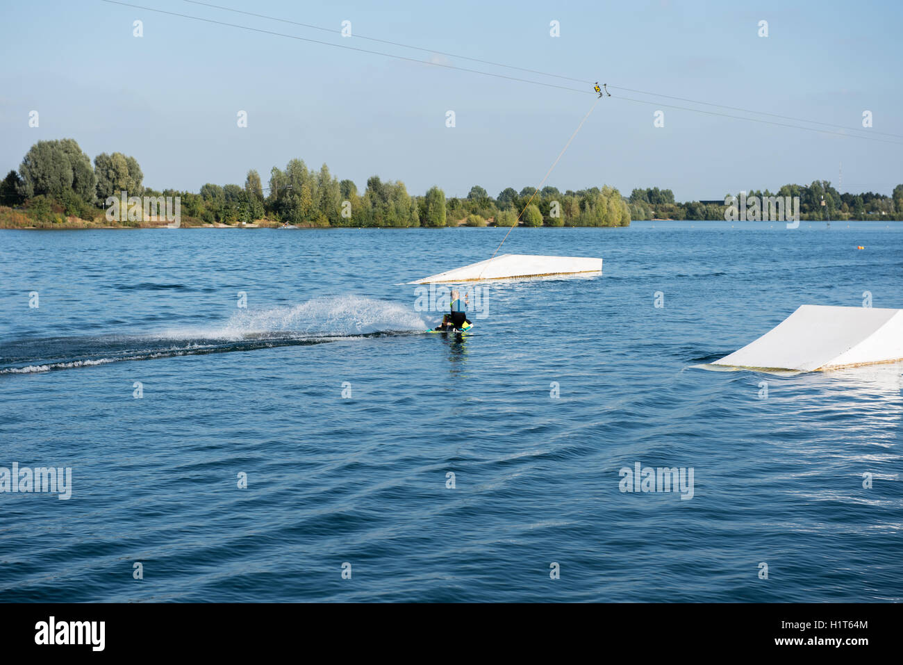 young boy is making a big wave with his wakeboard Stock Photo