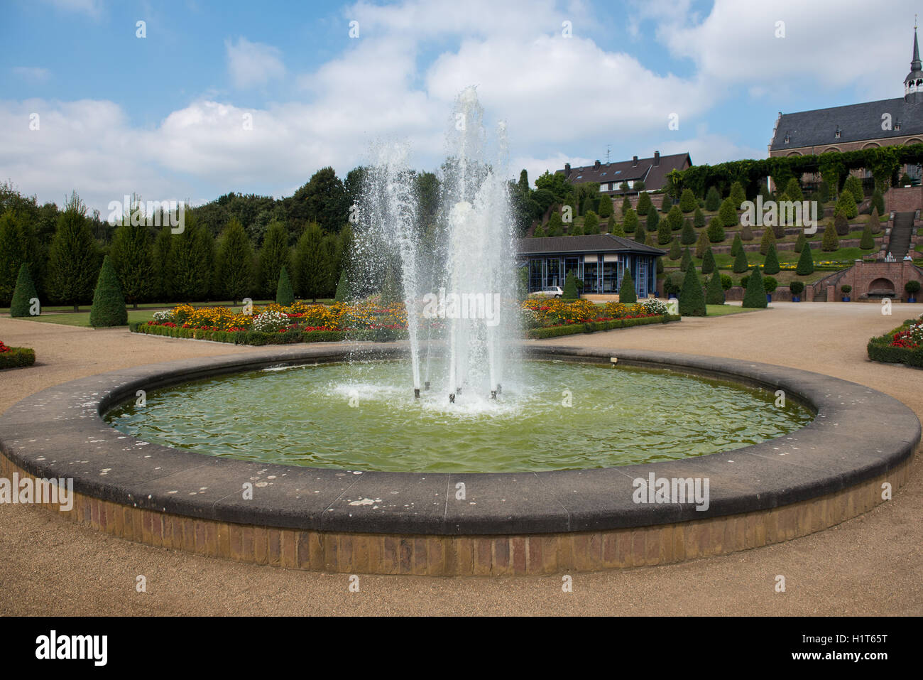 fountain in public park with trees and flowers Stock Photo - Alamy