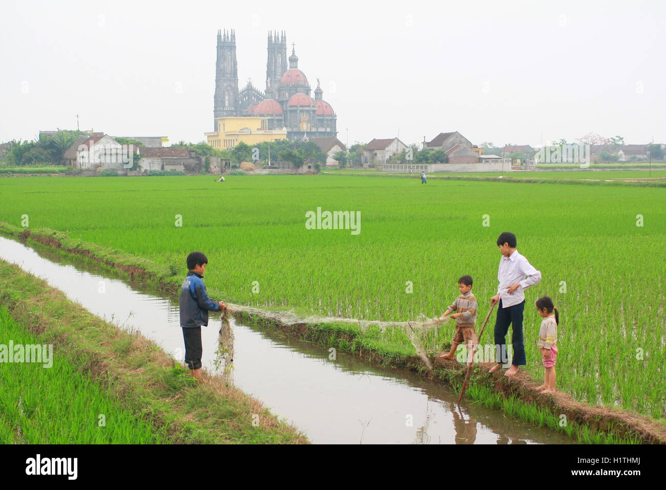 Nam Dinh, Vietnam - March 28, 2010: Children are playing in the paddy field in the countryside of the North of Vietnam Stock Photo